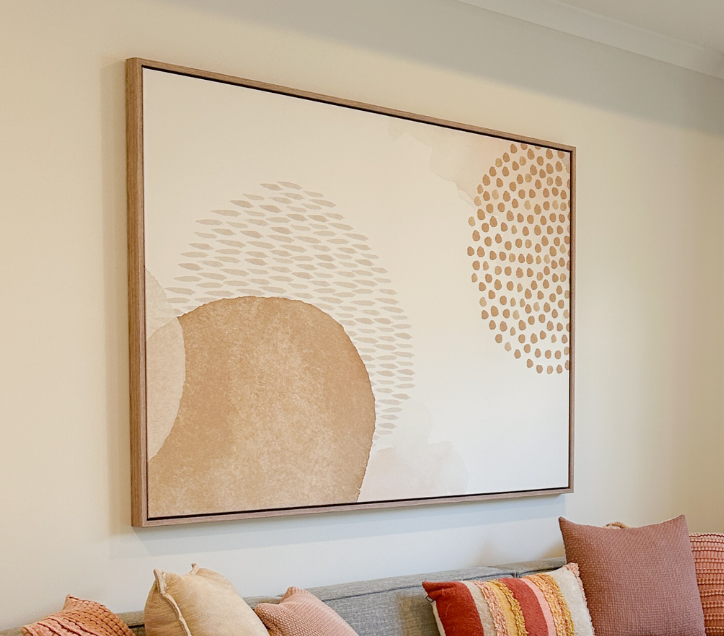 Large abstract canvas artwork hanging above a couch in a stylish living area.